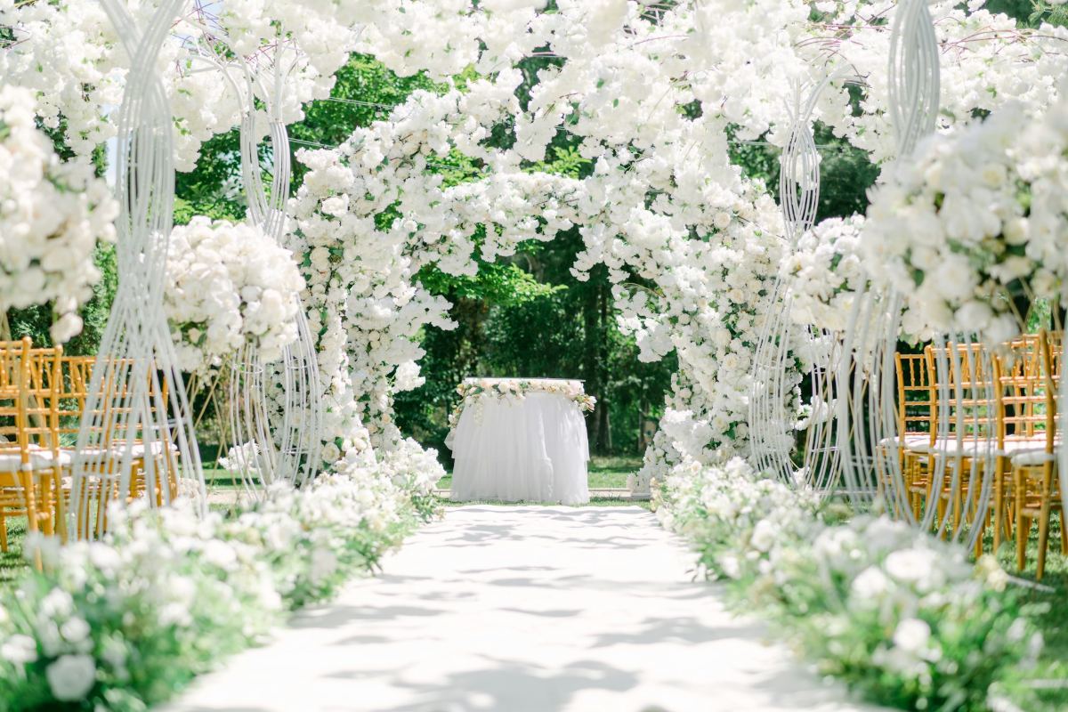 White floral wedding ceremony aisle with gold chairs
